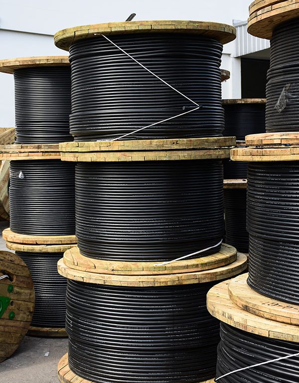 Wooden Coils Of Electric Cable Outdoor. High and low voltage cables in the storage.